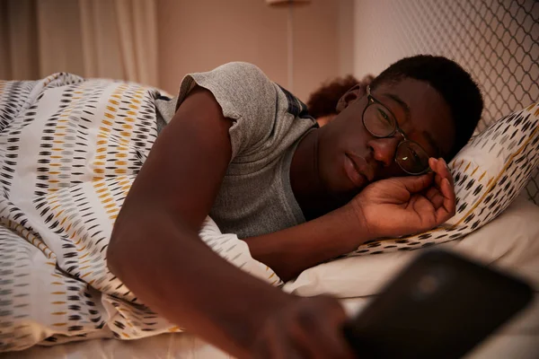 Χιλιάικα Αφρικανός Αμερικανός Άνθρωπος Μισοκοιμισμένος Στο Κρεβάτι Φορώντας Γυαλιά Και — Φωτογραφία Αρχείου
