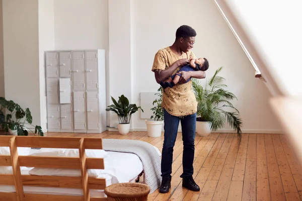 慈爱的父亲抱着新生儿在家里在阁楼公寓 — 图库照片