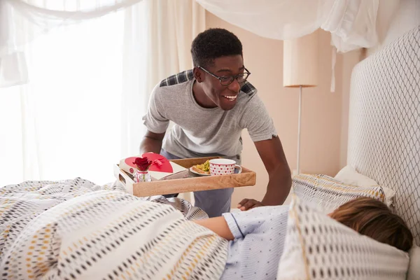 年轻夫妇庆祝情人节 男人带来伴侣早餐和礼物在床上 — 图库照片