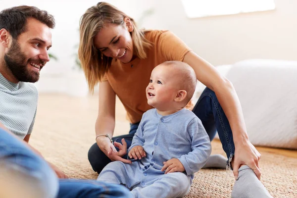 赤ちゃんの息子と遊んで家で床に座っている両親 — ストック写真