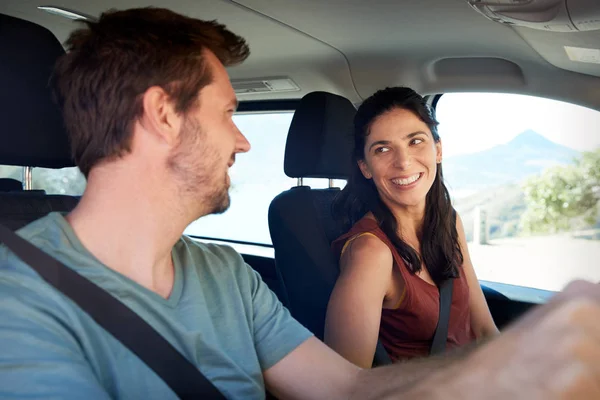 快乐的中年成年白人夫妇驾驶他们的车 互相微笑 侧视图 — 图库照片