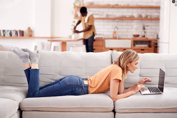 Woman Relaxing Lying Sofa Home Using Laptop Computer Man Kitchen Stock Photo