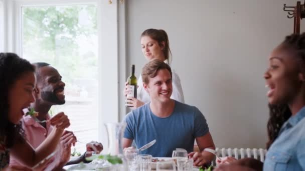 Официантка Наливает Вино Группы Молодых Друзей Сидящих Столом Обедающих Вместе — стоковое видео