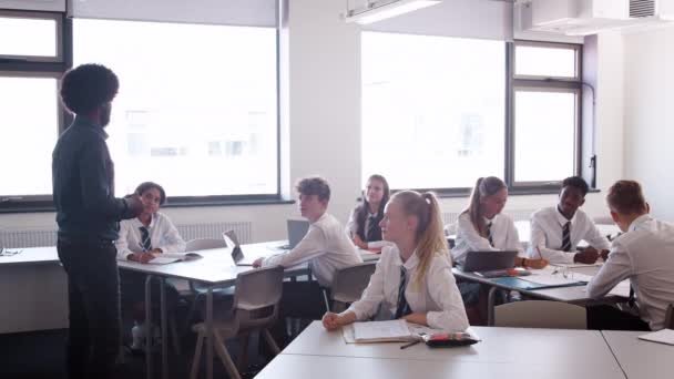 Manlig Gymnasielärare Stående Undervisning Klass Uniformerade Studenter Som Höjer Hand — Stockvideo