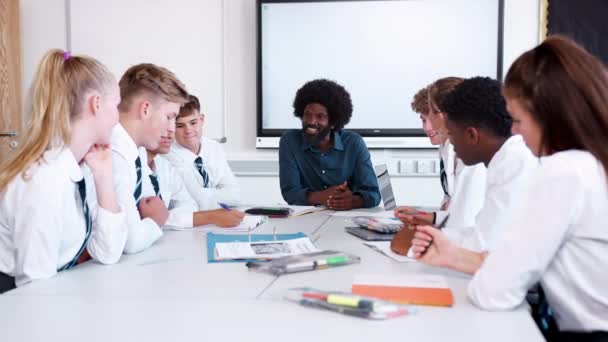 Männlicher Gymnasiallehrer Sitzt Tisch Mit Einer Gruppe Uniformierter Schüler Die — Stockvideo