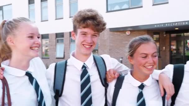 校舎の外に立つ制服姿の男女高校生の肖像画 ゆっくりと撮影 — ストック動画