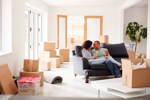 Pareja Tomando Descanso Sentada Sofá Celebrando Mudarse Una Nueva Casa — Foto de Stock