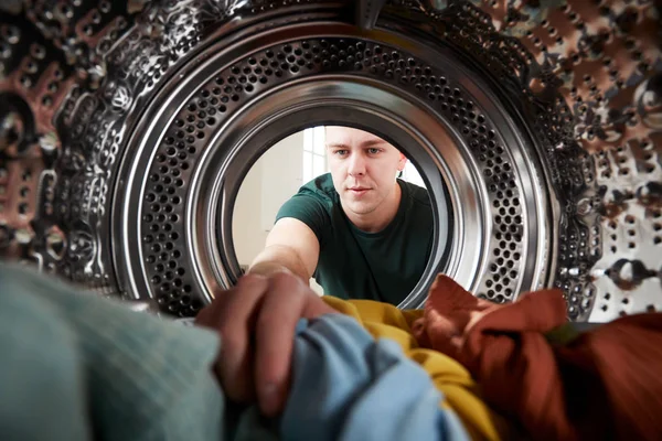 从洗衣机内部向外看 年轻人洗衣服 — 图库照片