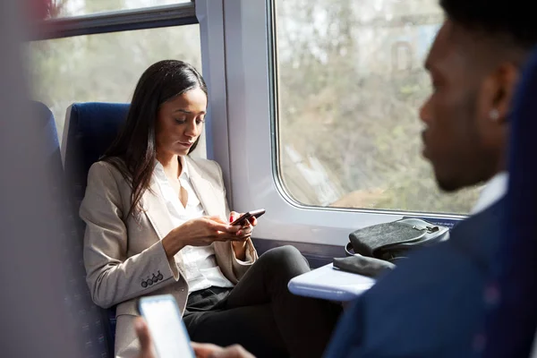 電車通勤中に座っているビジネス客が携帯電話を見て通勤 — ストック写真