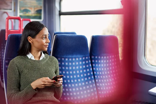Γυναίκα Επιβάτης Κάθεται Στο Τρένο Κοιτάζοντας Κινητό Τηλέφωνο — Φωτογραφία Αρχείου