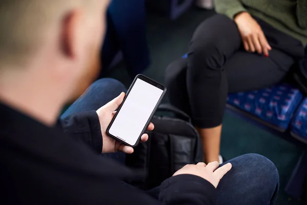 携帯電話のデジタルチケットで電車の中に座っている男性乗客のクローズアップ — ストック写真