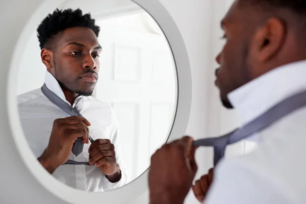 仕事に出かける前に鏡でネクタイを結ぶ自宅のビジネスマン — ストック写真