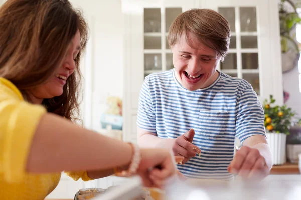年轻的唐氏综合症夫妇烘焙纸杯蛋糕在家里的厨房 — 图库照片
