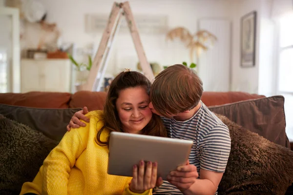 Kochający Młody Downs Syndrome Para Siedzący Kanapie Korzystanie Cyfrowego Tabletu — Zdjęcie stockowe