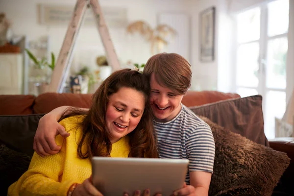 Amante Jovem Downs Síndrome Casal Sentado Sofá Usando Tablet Digital — Fotografia de Stock