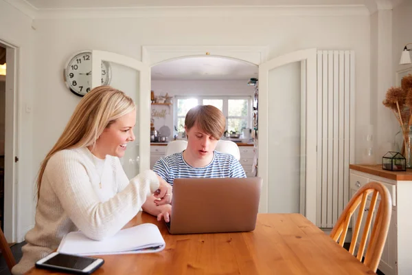 Downs Syndrome Człowiek Siedzi Nauczycielem Domowym Korzystanie Laptop Lekcji Domu — Zdjęcie stockowe