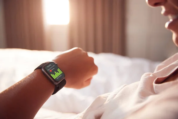 Yatakta Oturan Kadın Akıllı Saatin Ekranına Bakıyor — Stok fotoğraf