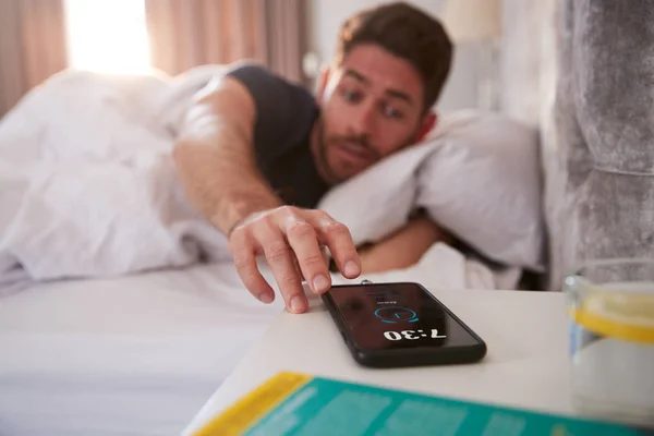 Man Waking Bed Reaches Out Turn Alarm Mobile Phone — Stok Foto