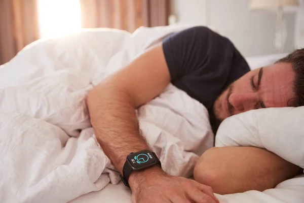 Hombre Durmiendo Cama Usando Reloj Inteligente Como Sol Rompe Través —  Fotos de Stock