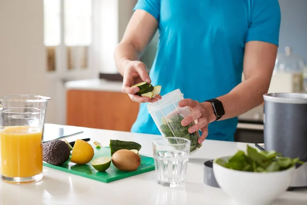 Close Up Of Man Preparing Ingredients For Healthy Juice Drink After Exercise