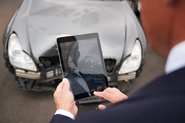 自動車事故による自動車の損傷のデジタルタブレットで写真を撮る保険損失調整器 — ストック写真