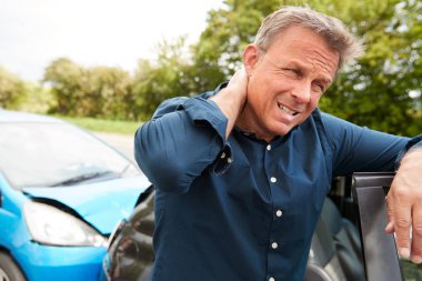 Mature Male Motorist With Whiplash Injury In Car Crash Getting Out Of Vehicle clipart