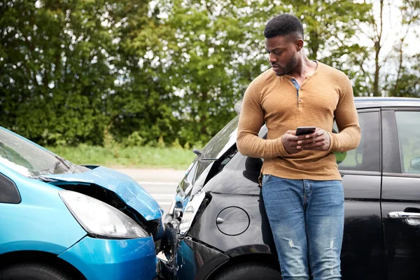 自動車事故に関与する男性運転手が保険会社または復旧サービスを呼び出す — ストック写真