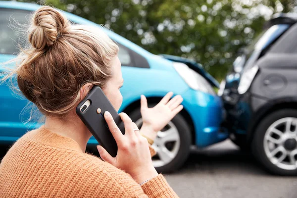 自動車事故に関与する女性運転手が保険会社または復旧サービスを呼び出す — ストック写真