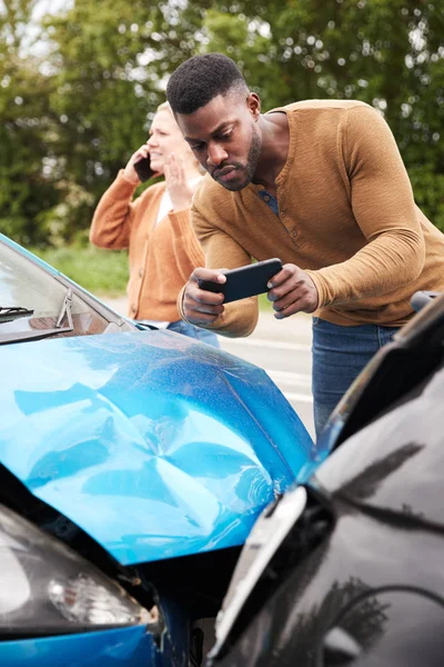 自動車事故に巻き込まれた男性運転手 保険金請求の損害賠償の写真を撮る — ストック写真