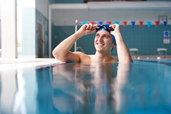 男子游泳运动员戴帽子和护目镜在游泳池训练 — 图库照片
