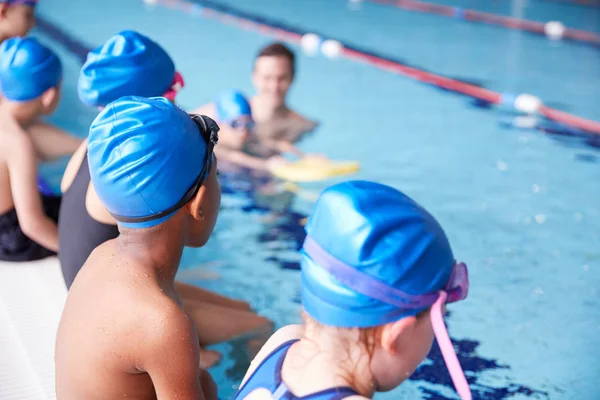 Maschio Allenatore Acqua Dando Gruppo Bambini Lezione Nuoto Piscina Coperta — Foto Stock