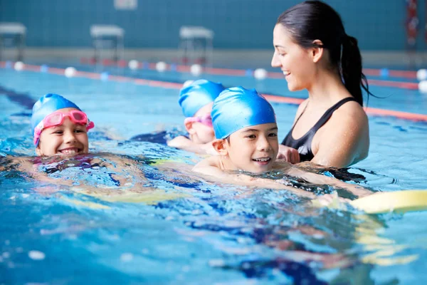 Kvinnlig Tränare Vatten Ger Grupp Barn Simlektioner Inomhuspool — Stockfoto