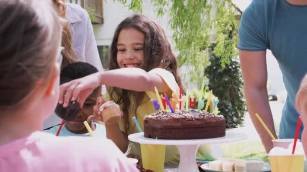 両親や友人と庭で屋外パーティーを楽しんで誕生日を祝う女の子 スローモーションで撮影 — ストック動画