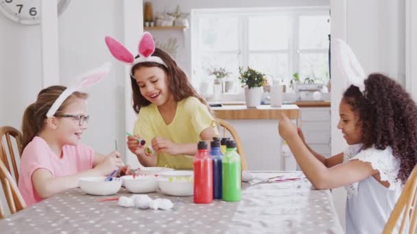 Groep Meisjes Zitten Rond Keukentafel Dragen Konijnenoren Versieren Eieren Voor — Stockvideo