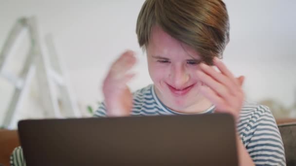 Homem Síndrome Downs Jovem Sentado Sofá Casa Usando Computador Portátil — Vídeo de Stock