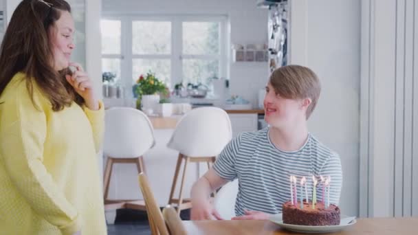 年轻的唐氏综合症夫妇在家里庆祝生日 在蛋糕上吹灭蜡烛 动作缓慢 — 图库视频影像