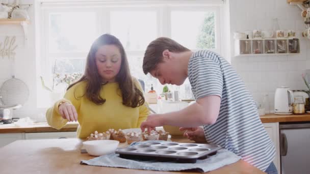 Jovens Downs Síndrome Casal Assar Cozinha Casa Decorar Cupcakes Com — Vídeo de Stock