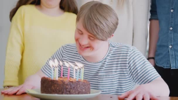 Young Downs Syndrome Man Celebrating Birthday Blowing Candles Out Cake — Stock Video