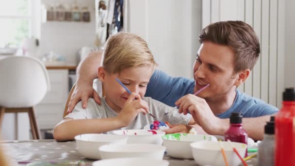 Vader Zit Aan Keukentafel Helpen Zoon Eieren Schilderen Voor Pasen — Stockvideo