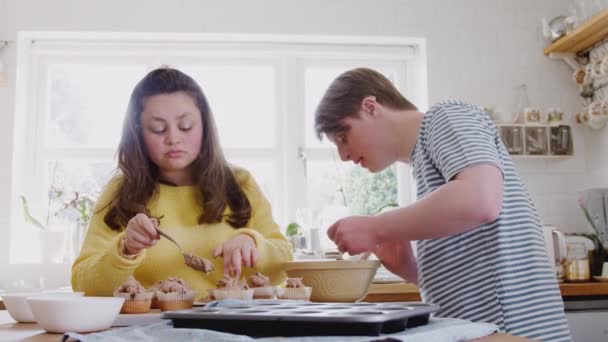 Síndrome Young Downs Pareja Horneando Cocina Casa Decorando Cupcakes Con — Vídeo de stock