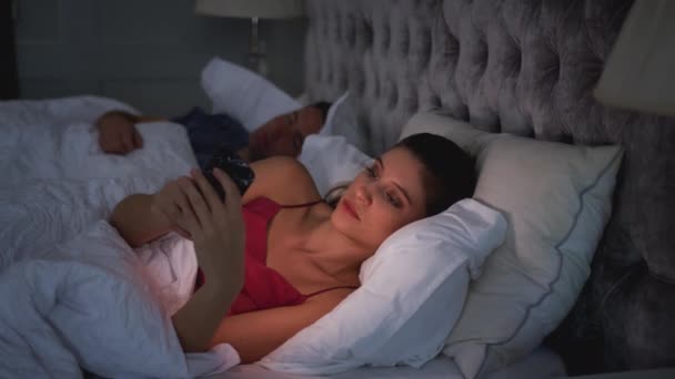 Mujer Acostada Cama Revisando Teléfono Móvil Mientras Compañero Sexo Masculino — Vídeos de Stock