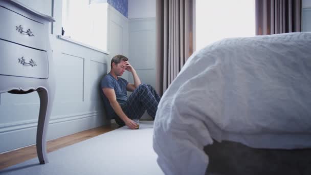 Camera Tracks Frame Depressed Man Sits Floor Wearing Pajamas Drinking — Stock Video