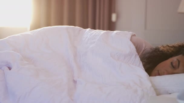 女性は眠ってベッドで彼女がオフになっている音声アシスタントにアラームによって起こされている スローモーションで撮影 — ストック動画