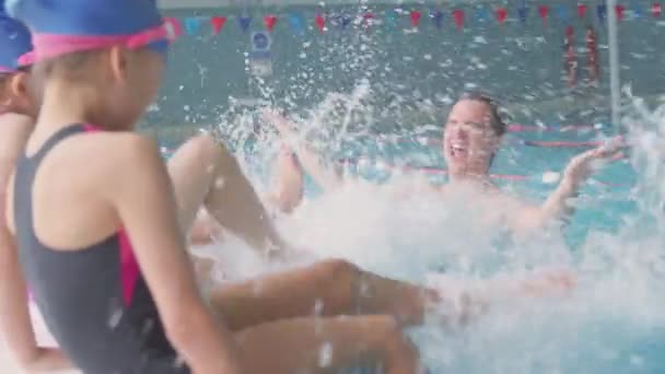 Bambini Che Schizzano Allenatore Maschile Piscina Mentre Siedono Sul Bordo — Video Stock