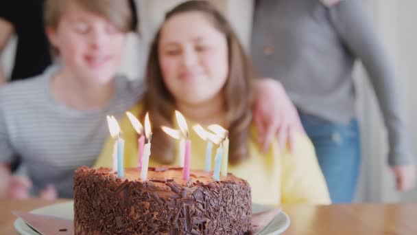 若いですダウン症候群カップルお祝いの誕生日吹いてキャンドルアウトケーキに家 ショットでスローモーション — ストック動画