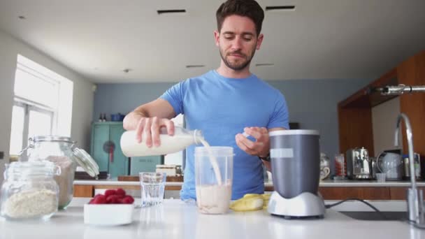 身穿健美服装的男人 在搅拌机配料中加入杏仁牛奶 以促进蛋白质的健康 慢动作射击 — 图库视频影像