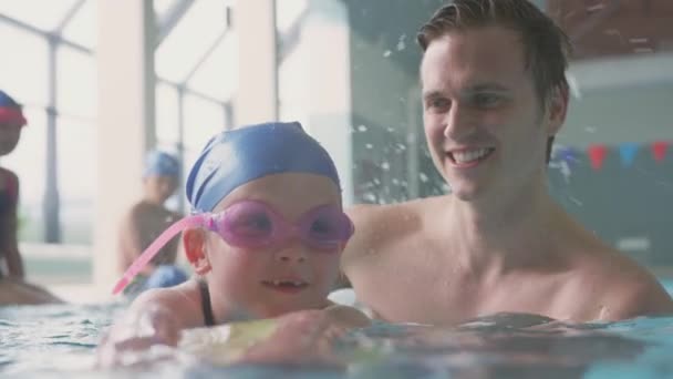 Male Swimming Teacher Giving Girl Holding Float Lesson Pool Shot — Stok video