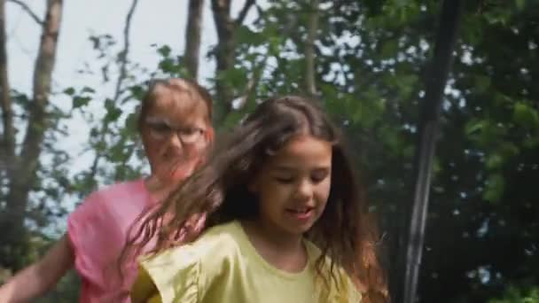 Bahçede Eğlenen Bir Grup Çocuk Birlikte Trambolinde Zıplıyorlar Ağır Çekimde — Stok video