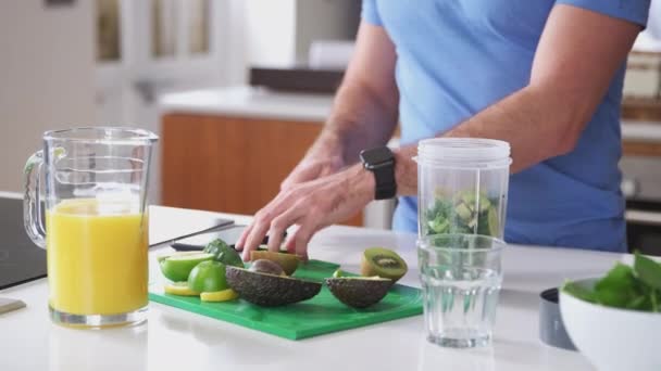 穿着健美衣服的人把水果和蔬菜切碎制成健康饮料 然后慢镜头加进果汁机 — 图库视频影像