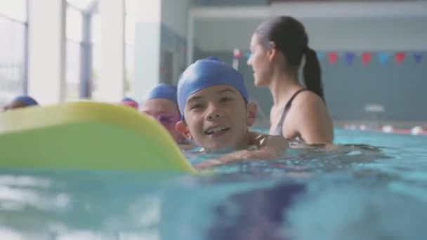 在水里给孩子们上室内游泳池游泳课的女教练 慢动作射击 — 图库视频影像